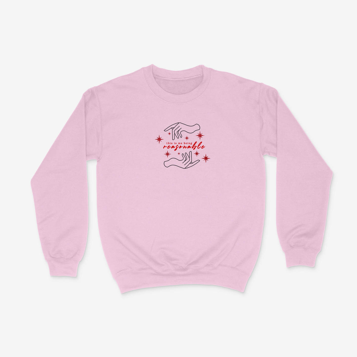 Pink crewneck sweater featuring hand design, sparkly red stars, and the phrase "This is me being resasonable" .