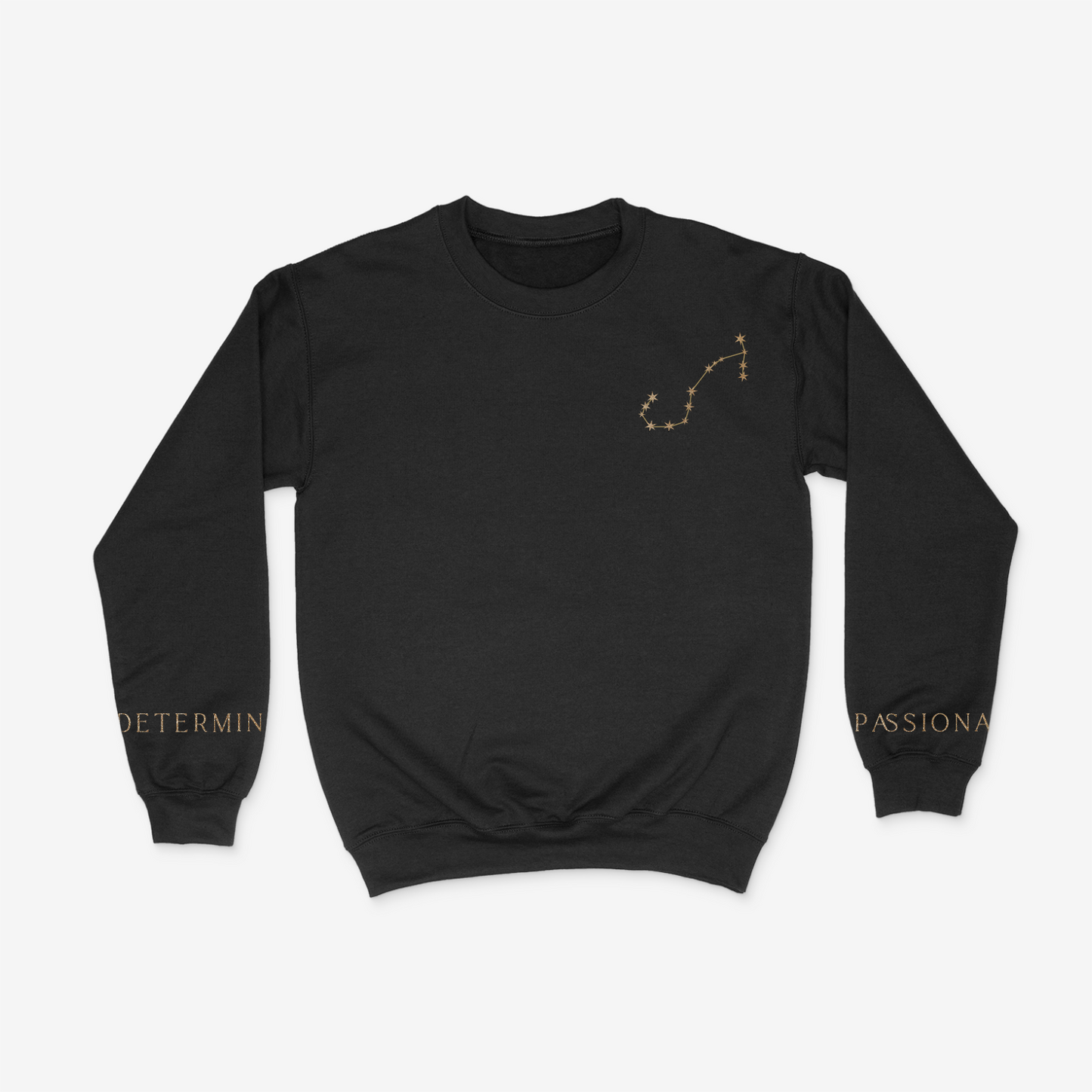 Black crewneck sweater with gold Scorpio constellation on upper right chest pocket area and "determined" and "passionate" written on the wrists of either sleeve